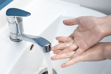 Image showing Woman washing hands carefully in bathroom close up. Prevention of infection and pneumonia virus spreading