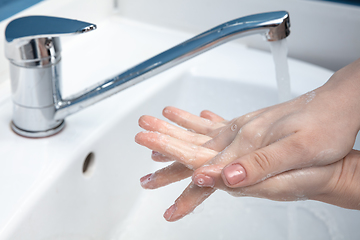 Image showing Woman washing hands carefully in bathroom close up. Prevention of infection and pneumonia virus spreading