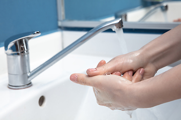 Image showing Woman washing hands carefully in bathroom close up. Prevention of infection and pneumonia virus spreading