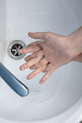 Image showing Woman washing hands carefully in bathroom close up. Prevention of infection and pneumonia virus spreading