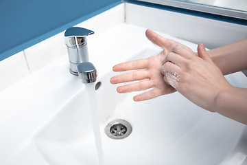 Image showing Woman washing hands carefully in bathroom close up. Prevention of infection and pneumonia virus spreading