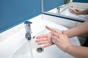 Image showing Woman washing hands carefully in bathroom close up. Prevention of infection and pneumonia virus spreading