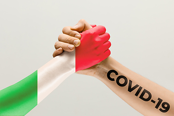 Image showing Human hands colored in flag of Italy and coronavirus - concept of spreading of virus, fighting