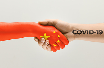 Image showing Human hands colored in flag of China and coronavirus - concept of spreading of virus