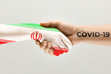 Image showing Human hands colored in flag of Iran and coronavirus - concept of spreading of virus