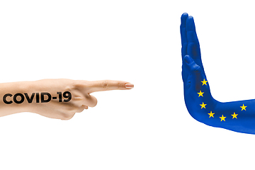 Image showing Stop the epidemic. Human hands colored in flag of European Unity and coronavirus - concept of spreading of virus