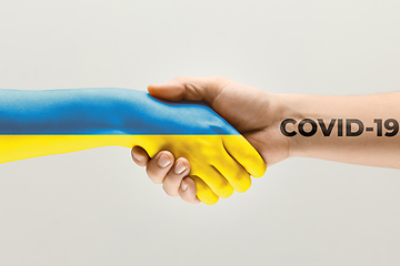 Image showing Human hands colored in flag of Ukraine and coronavirus - concept of spreading of virus
