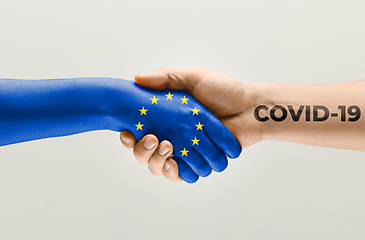 Image showing Human hands colored in flag of Europian Union and coronavirus - concept of spreading of virus