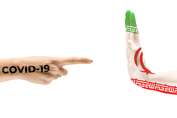 Image showing Stop the epidemic. Human hands colored in flag of Iran and coronavirus - concept of spreading of virus