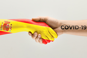 Image showing Human hands colored in flag of Spain and coronavirus - concept of spreading of virus, fighting