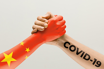 Image showing Human hands colored in flag of China and coronavirus - concept of spreading of virus, fighting