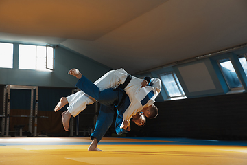 Image showing Two young judo fighters in kimono training martial arts in the gym with expression, in action and motion