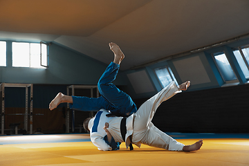 Image showing Two young judo fighters in kimono training martial arts in the gym with expression, in action and motion