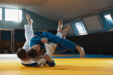 Image showing Two young judo fighters in kimono training martial arts in the gym with expression, in action and motion