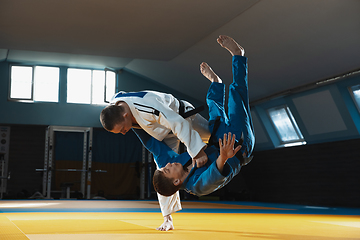 Image showing Two young judo fighters in kimono training martial arts in the gym with expression, in action and motion