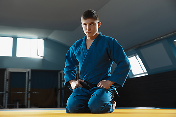 Image showing Young judo fighter in kimono posing comfident in the gym, strong and healthy