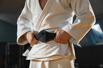 Image showing Young judo fighter in kimono posing comfident in the gym, strong and healthy