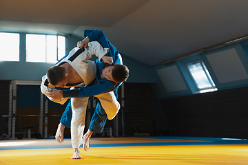 Image showing Two young judo fighters in kimono training martial arts in the gym with expression, in action and motion