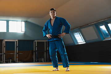 Image showing Young judo fighter in kimono posing comfident in the gym, strong and healthy