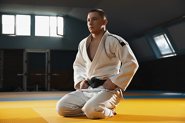 Image showing Young judo fighter in kimono posing comfident in the gym, strong and healthy