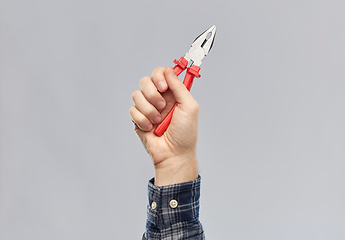 Image showing close up of builder's hand holding pliers