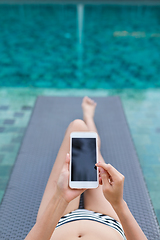 Image showing Woman use of mobile phone with swimming pool