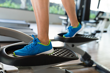 Image showing Woman doing exercises in the gym on elliptical cross trainer