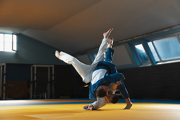 Image showing Two young judo fighters in kimono training martial arts in the gym with expression, in action and motion