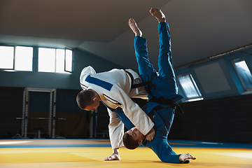 Image showing Two young judo fighters in kimono training martial arts in the gym with expression, in action and motion