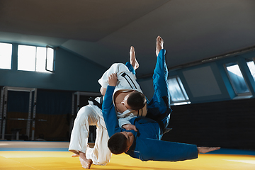 Image showing Two young judo fighters in kimono training martial arts in the gym with expression, in action and motion