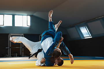 Image showing Two young judo fighters in kimono training martial arts in the gym with expression, in action and motion