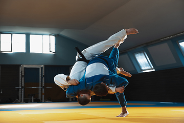 Image showing Two young judo fighters in kimono training martial arts in the gym with expression, in action and motion