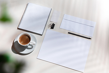 Image showing Creative and cozy workplace at home office, inspirational mock up with plant shadows on table surface