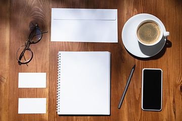 Image showing Creative and cozy workplace at home office, inspirational mock up with plant shadows on table surface