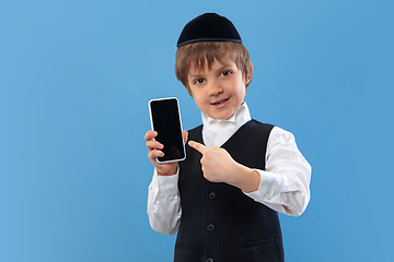 Image showing Portrait of a young orthodox jewish boy isolated on blue studio background, meeting the Passover