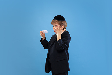 Image showing Portrait of a young orthodox jewish boy isolated on blue studio background, meeting the Passover