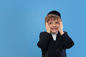 Image showing Portrait of a young orthodox jewish boy isolated on blue studio background, meeting the Passover