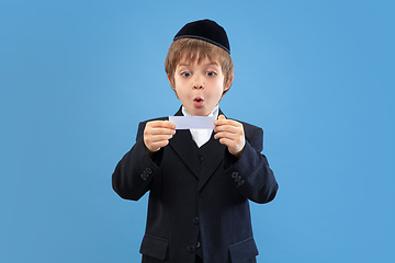 Image showing Portrait of a young orthodox jewish boy isolated on blue studio background, meeting the Passover