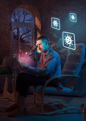 Image showing Shocked, upset and sad man using gadgets to get information of coronavirus pandemic spread