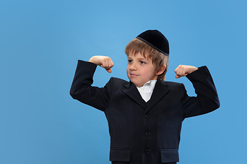 Image showing Portrait of a young orthodox jewish boy isolated on blue studio background, meeting the Passover