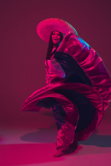 Image showing Fabulous Cinco de Mayo female dancer on purple studio background in neon light