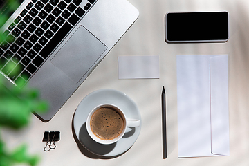 Image showing Creative and cozy workplace at home office, inspirational mock up with plant shadows on table surface