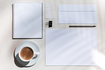 Image showing Creative and cozy workplace at home office, inspirational mock up with plant shadows on table surface