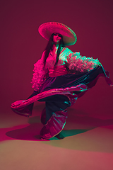 Image showing Fabulous Cinco de Mayo female dancer on purple studio background in neon light