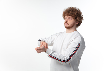 Image showing How coronavirus changed our lives. Young man taking pulse on white background