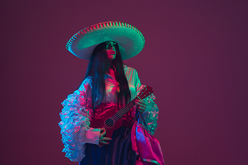 Image showing Fabulous Cinco de Mayo female dancer on purple studio background in neon light