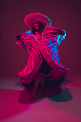 Image showing Fabulous Cinco de Mayo female dancer on purple studio background in neon light