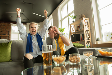 Image showing Excited family watching football, sport match at home, beautiful couple