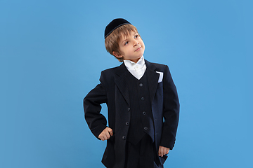 Image showing Portrait of a young orthodox jewish boy isolated on blue studio background, meeting the Passover