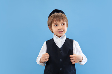 Image showing Portrait of a young orthodox jewish boy isolated on blue studio background, meeting the Passover